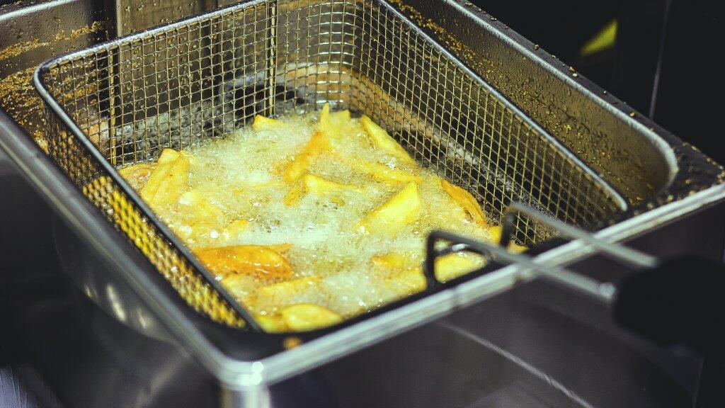 Frites in een friteuse, sissend in hete olie.