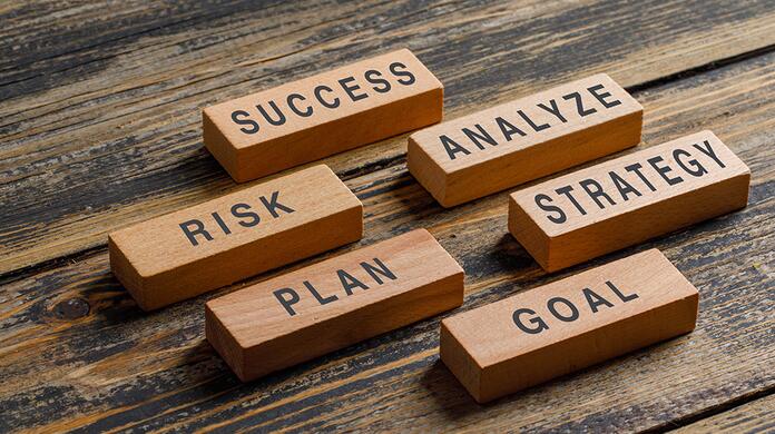 Succesvolle houten blokken met termen: succes, analyse, strategie, risico, plan, doel.